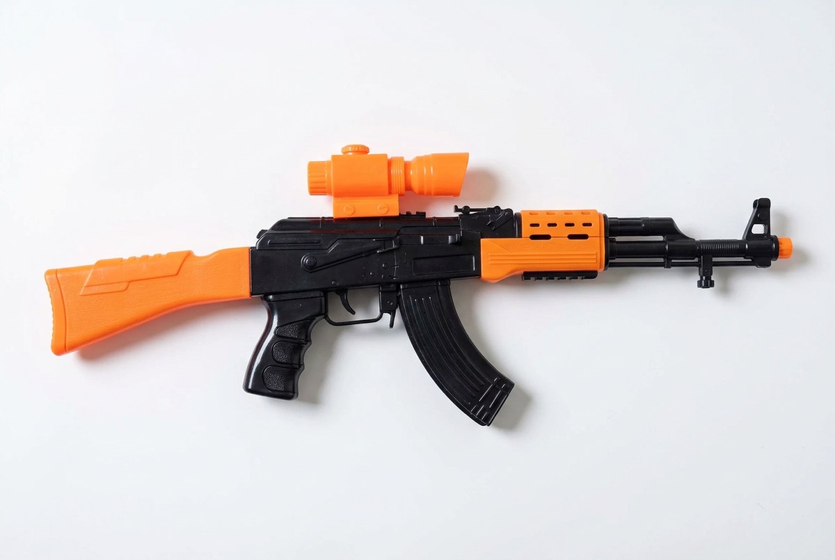 Black-and-orange toy blaster on white