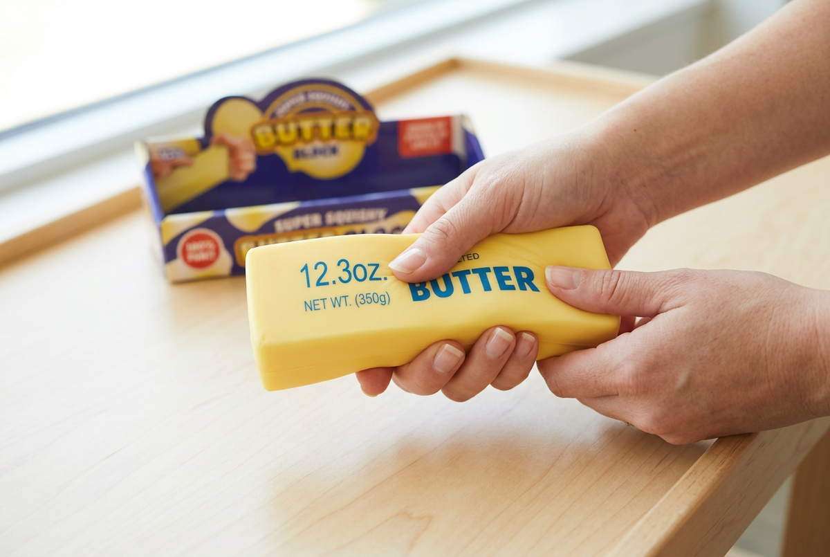 Hands squeezing the butter block toy